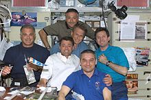 The two crews share a meal on ISS.