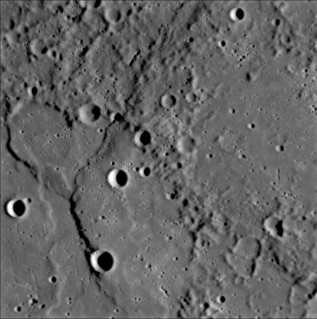 One of the first photos taken of Mercury's surface by the MESSENGER probe, showing ridges and cliffs along with craters.